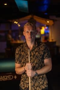dating profile photo of a man playing pool in Amsterdam